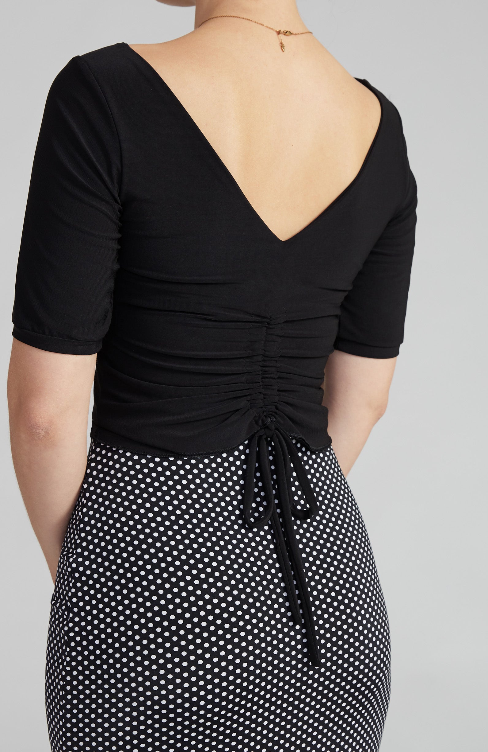 Detail view of draped tango top in black