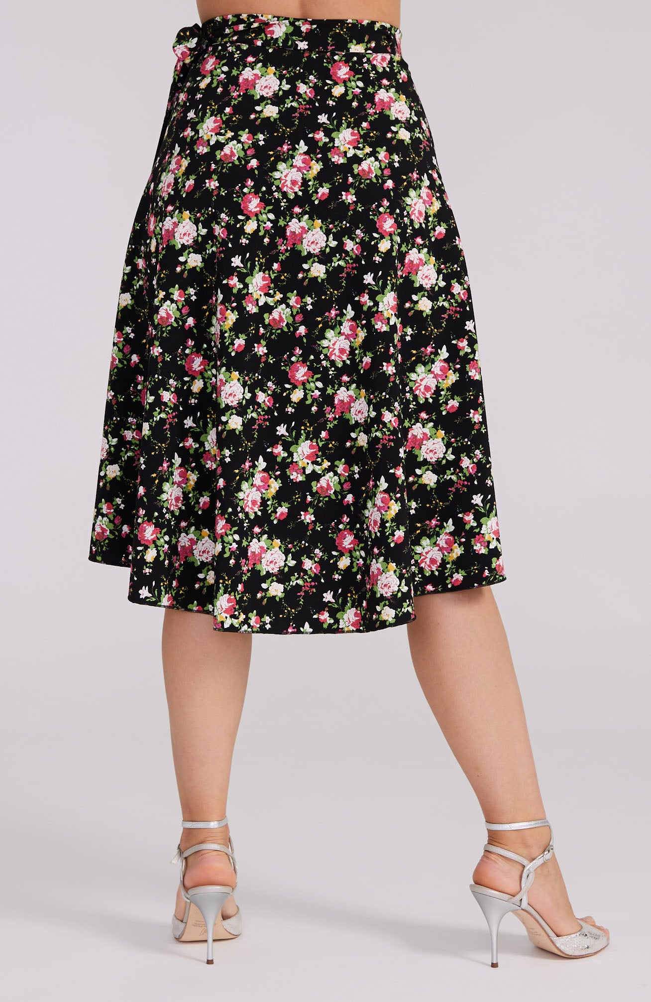 Model wearing the COCO red rose print tango skirt, showcasing the asymmetric wrap design and elegant movement on the dance floor.