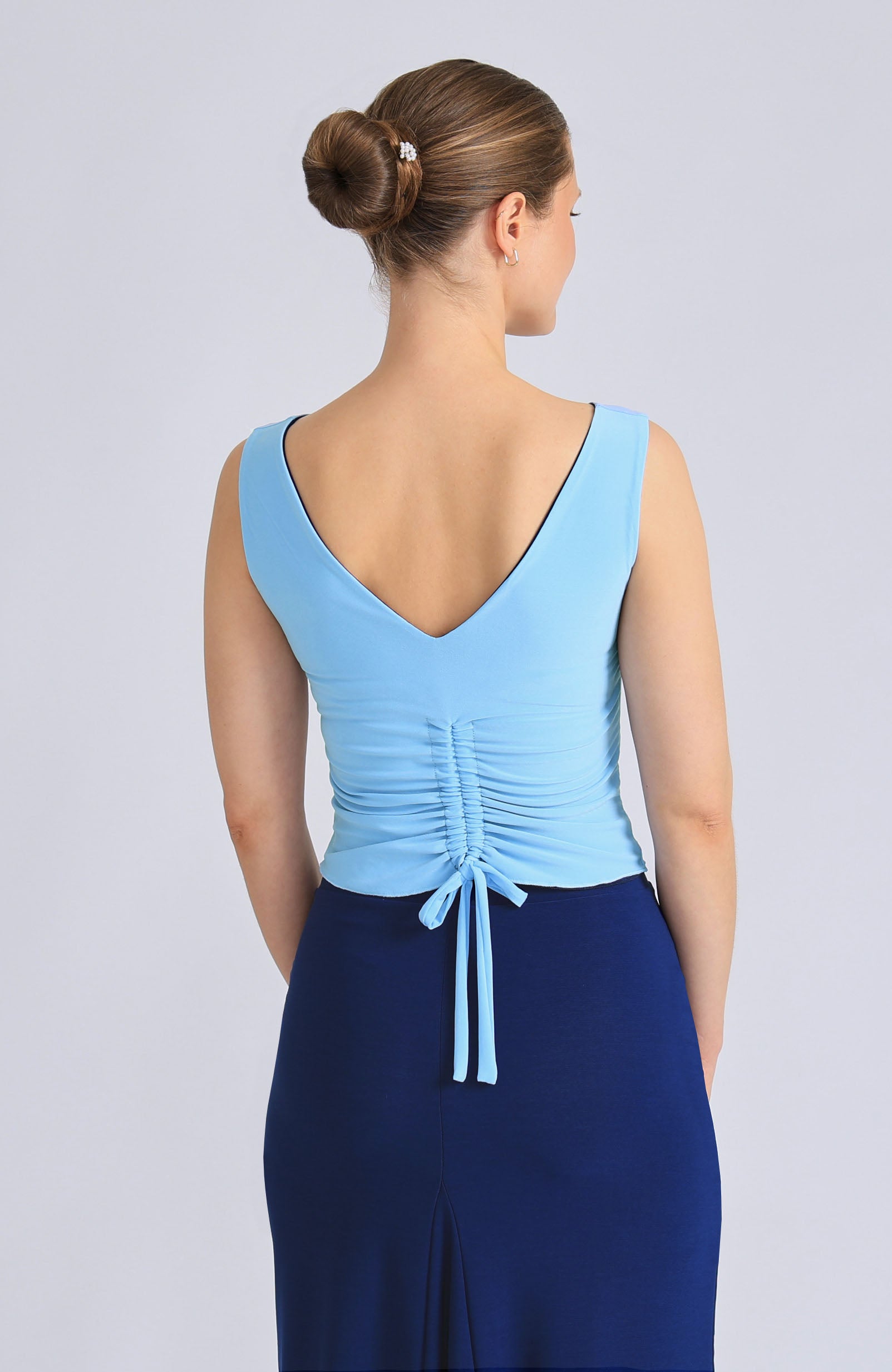 Reversible DORA top in baby blue and classic blue, showcasing the elegant draped back with an adjustable tie.