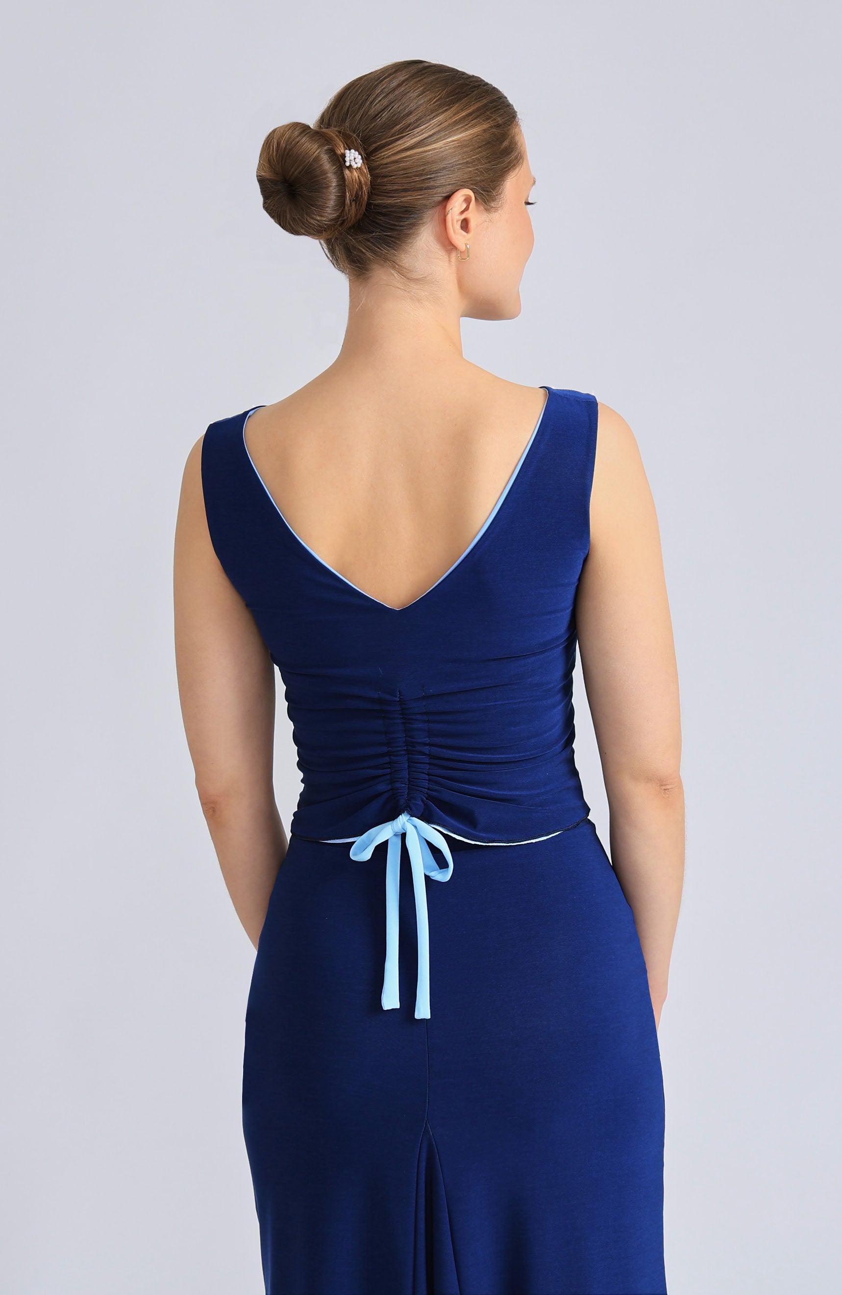 Reversible DORA top in baby blue and classic blue, showcasing the elegant draped back with an adjustable tie.