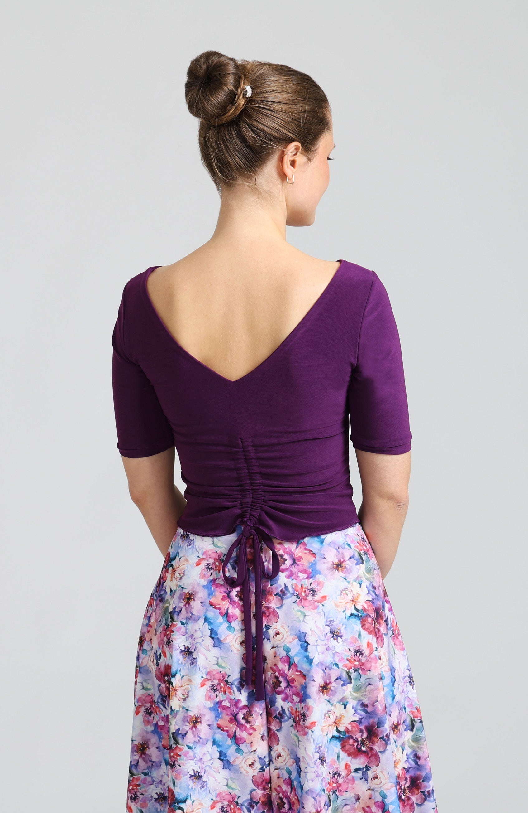 Adjustable back ties on the violet Dorotea draped back dance top with sleeves.