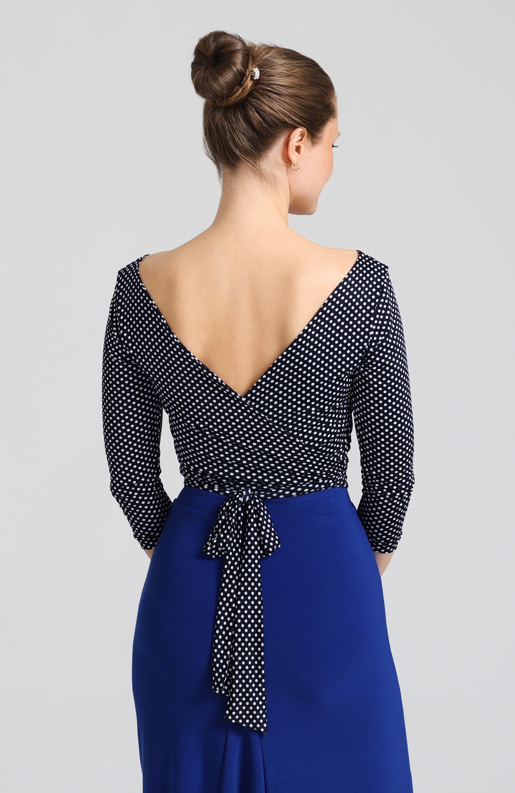 Navy blue polka dot wrap top ELLA with sleeves, featuring a charming V-back that ties into a beautiful bow.
