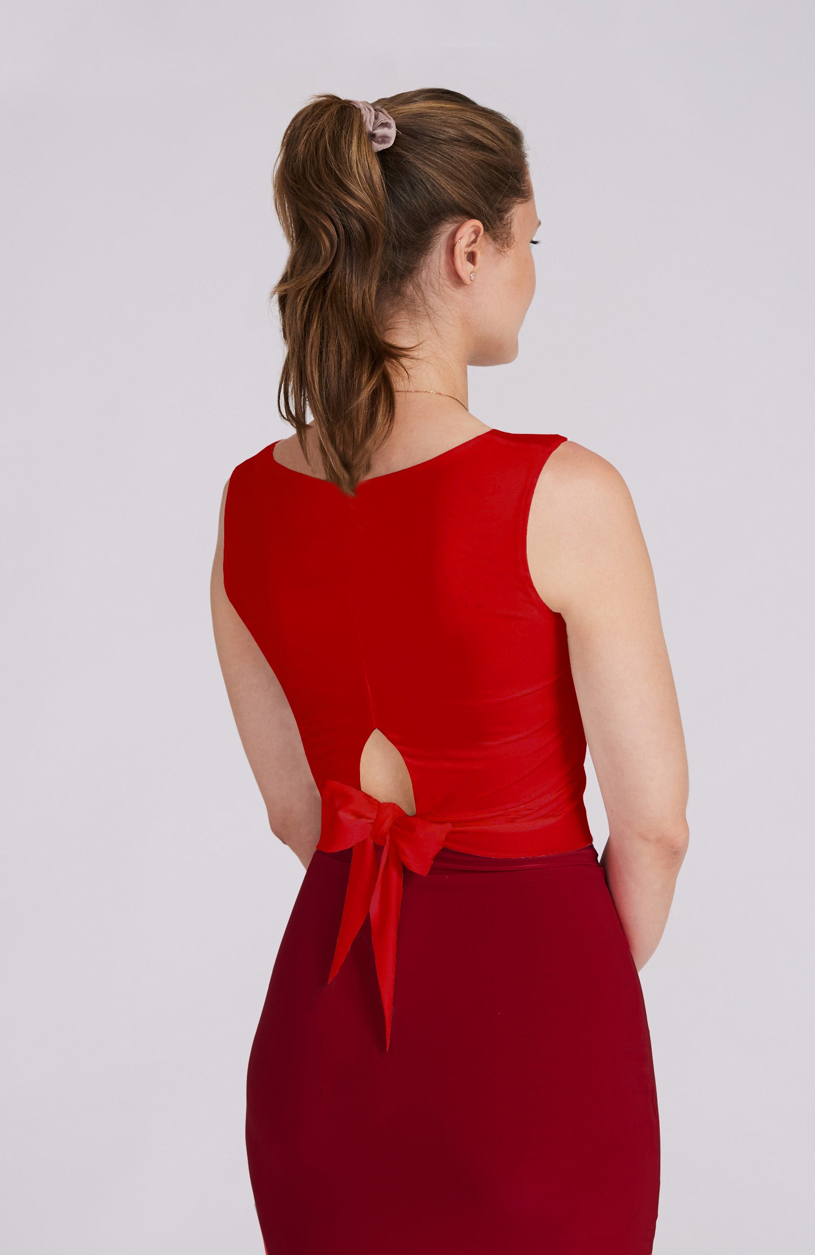 Model wearing the ZOE red tango top with a back bow detail.